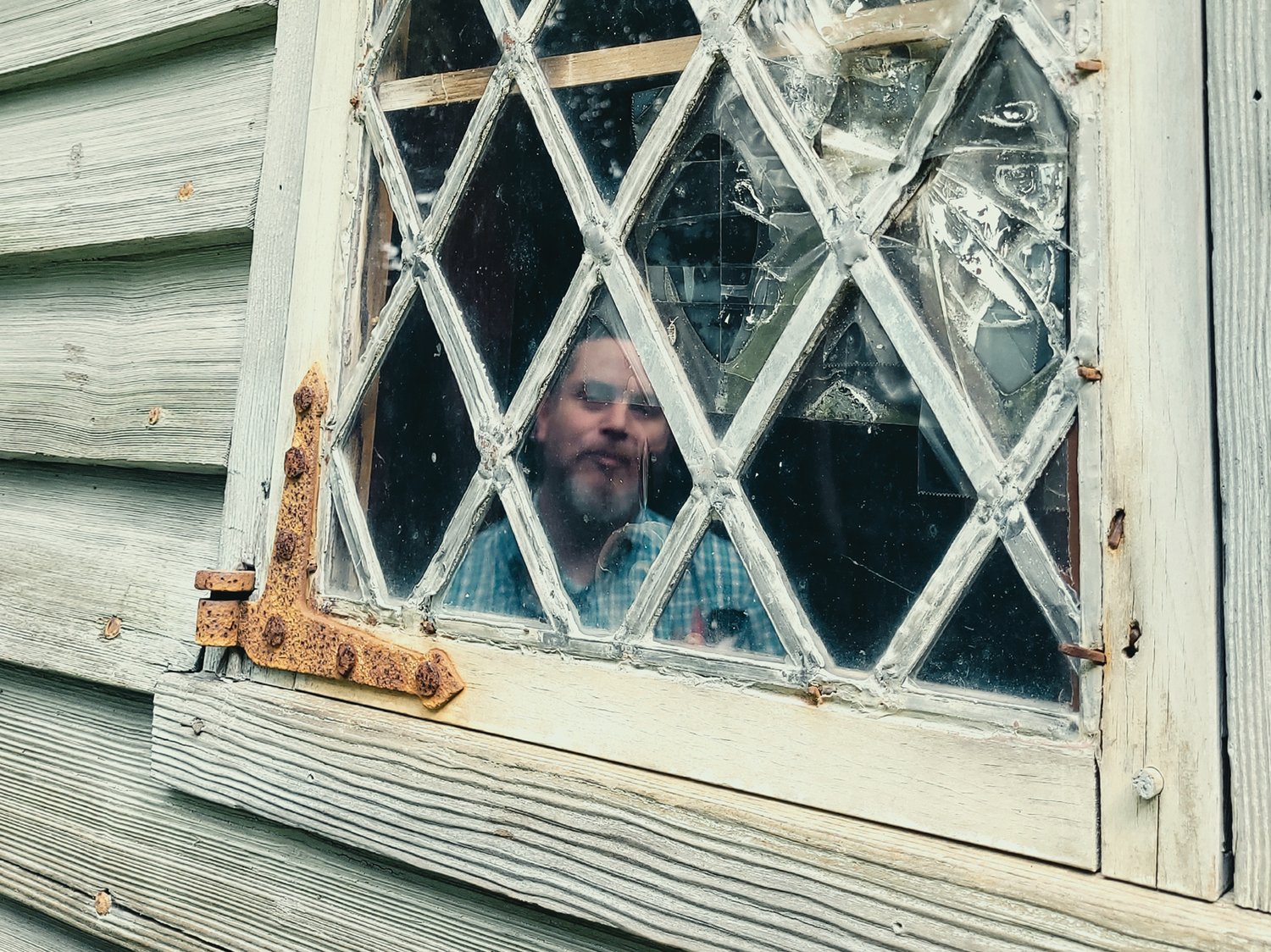 BROKEN GLASS: Historic New England representative Dan Santos, regional site administrator for Southern New England inspects a broken window at the Clemence-Irons House in Johnston.